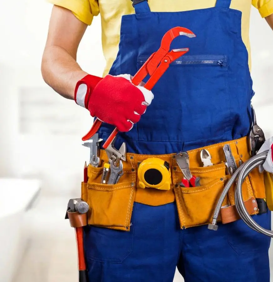 A man holding a wrench and some tools